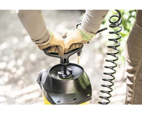 Person bedient Drucksprühgerät mit Handschuhen