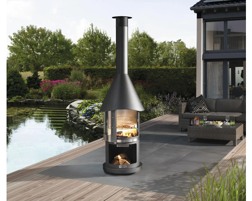 Cheminée de barbecue sur une terrasse avec jardin et étang en arrière-plan.