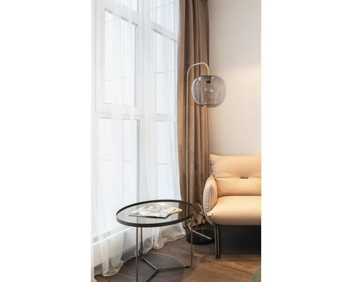 Salon avec lampadaire, table et fauteuil
