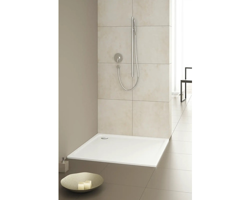 Ebenerdige Dusche mit Duschkopf und Armatur in einem hellen Badezimmer.
