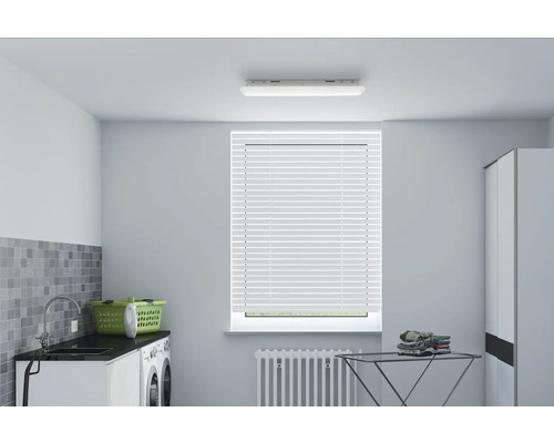 Heller Waschraum mit Waschmaschine, Spüle, Wäschekorb, Wäscheständer und Jalousie