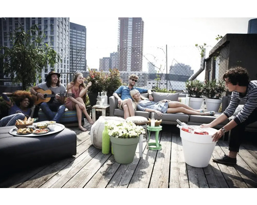 Gruppe von Menschen entspannt auf einer Dachterrasse mit Möbeln und Pflanzenkübeln.