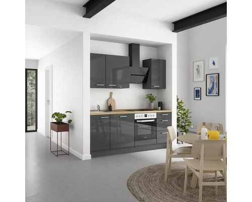 Cuisine lumineuse avec armoires grises, hotte aspirante et table à manger