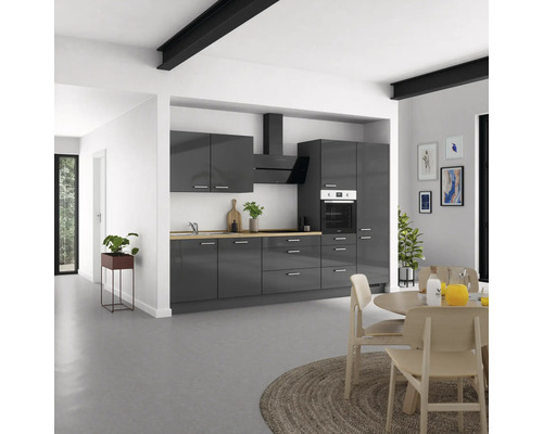 Cuisine moderne avec armoires grises, hotte aspirante et plan de travail en bois dans une pièce lumineuse.