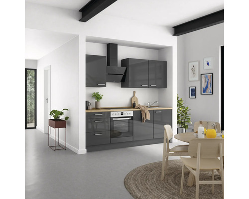 Cuisine moderne avec armoires grises, hotte aspirante et plans de travail en bois.