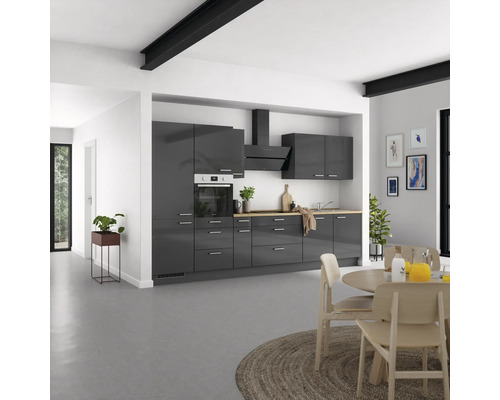 Cuisine moderne avec armoires grises, plaque de cuisson, hotte aspirante et table à manger
