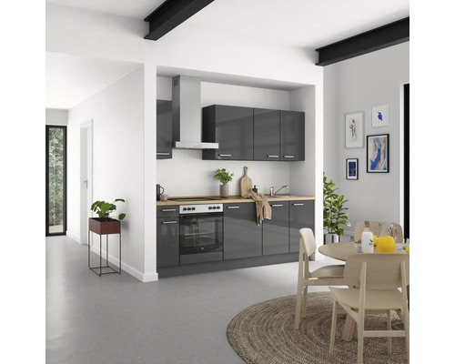 Cuisine lumineuse avec armoires grises, table à manger et chaises.