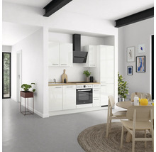 Cuisine claire avec armoires blanches, hotte aspirante, plaque de cuisson et coin repas