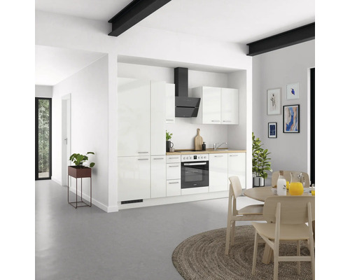 Cuisine claire avec placards intégrés, hotte aspirante et table à manger avec chaises