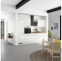 Cuisine claire avec armoires blanches, hotte aspirante et table à manger