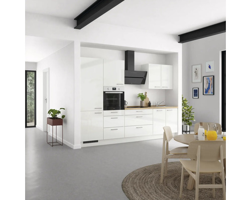 Cuisine claire avec armoires blanches, hotte aspirante et table à manger
