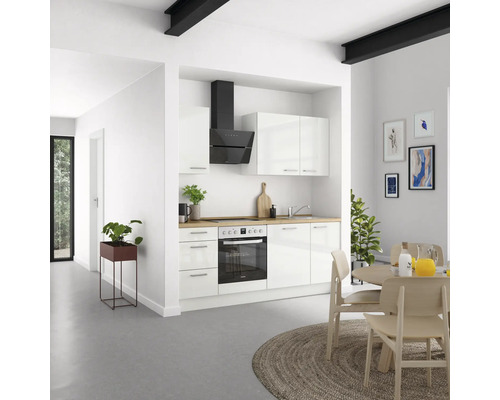 Cuisine claire avec armoires blanches, hotte noire et plan de travail en bois dans une ambiance moderne.