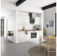 Cuisine claire avec armoires blanches, hotte aspirante et plan de travail en bois.