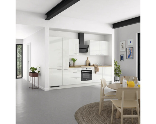 Cuisine moderne avec armoires blanches, hotte aspirante et plan de travail en bois dans une pièce lumineuse.