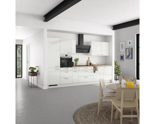 Cuisine lumineuse avec armoires blanches, hotte et table à manger