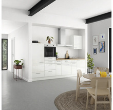 Cuisine lumineuse avec armoires blanches, hotte aspirante et plan de travail en bois dans une maison moderne