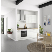 Cuisine lumineuse avec armoires blanches, hotte aspirante et table à manger