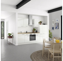 Espace de vie lumineux avec cuisine intégrée blanche, table à manger et décorations.