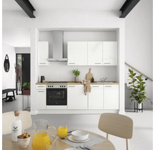 Cuisine lumineuse avec armoires blanches, évier, cuisinière et hotte aspirante dans une maison moderne.