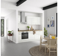 Cuisine lumineuse avec armoires blanches, hotte aspirante et plan de travail en bois dans une maison moderne.