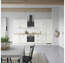 Cuisine claire avec armoires blanches, hotte aspirante et plan de travail en bois.