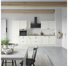 Cuisine claire avec armoires blanches, hotte aspirante et plans de travail en bois.