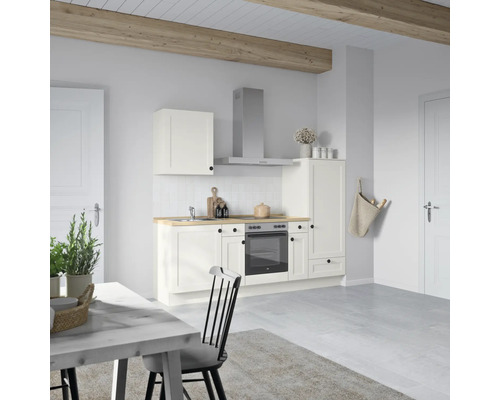 Helle Küche mit Hängeschrank, Dunstabzugshaube, Spüle, Herd, Backofen und Esstisch in einem hellen Raum.