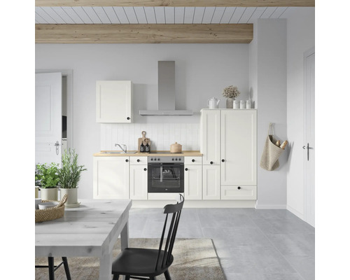 Cuisine claire avec armoires blanches, hotte aspirante et plan de travail en bois.