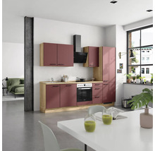 Cuisine moderne avec évier, cuisinière, hotte et table à manger dans une pièce lumineuse.