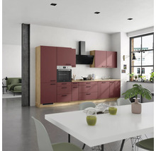 Cuisine moderne avec four intégré, hotte aspirante et table à manger dans une pièce lumineuse.