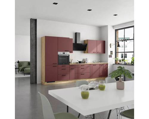 Cuisine moderne avec four intégré, hotte aspirante et table à manger dans une pièce lumineuse.