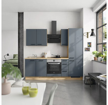 Moderne Küche mit blauen Schränken, Dunstabzugshaube und Elektroherd in einem hellen Raum.