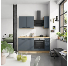 Cuisine moderne avec armoires de cuisine, évier, plaque de cuisson, hotte aspirante et four dans une pièce lumineuse.