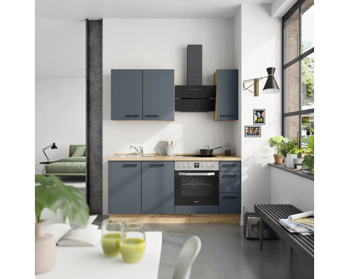 Cuisine moderne avec armoires de cuisine, évier, plaque de cuisson, hotte aspirante et four dans une pièce lumineuse.