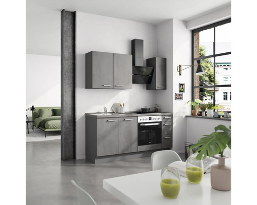 Cuisine avec armoires grises, évier, cuisinière et hotte aspirante dans un espace de vie moderne.