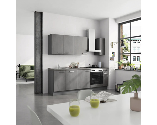 Moderne Küche mit grauen Schränken, Arbeitsplatte und Essecke in einem hellen Raum.