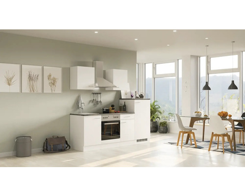 Helle Küche mit Küchenzeile, Dunstabzugshaube und Essbereich in einem offenen Raum.