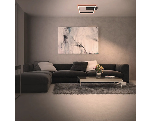 Wohnzimmer mit Sofa, Tisch und quadratischer Deckenleuchte