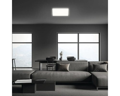 Modernes Wohnzimmer mit Sofa, Esstisch und quadratischer Deckenleuchte