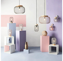 Raumansicht mit Hängeleuchten, Tischleuchten und Wandleuchten aus Metall und Holz auf unterschiedlich farbigen Sockeln