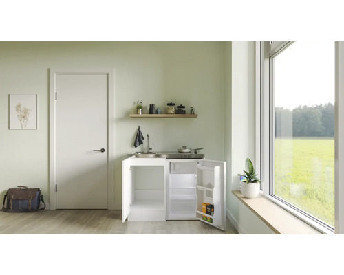 Cuisine compacte avec évier, plaque de cuisson et réfrigérateur dans une pièce lumineuse