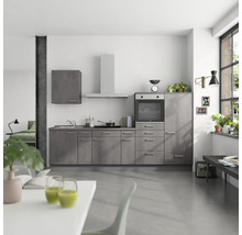 Helle Küche mit Küchenschränken, Spüle, Herd, Backofen, Dunstabzugshaube und Arbeitsplatte.