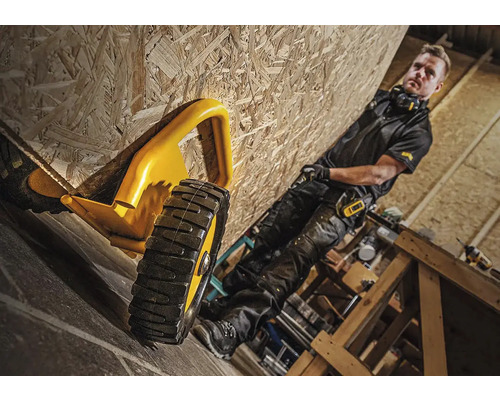 Gelber Rollgabelschlüssel und Handwerker in einer Werkstatt mit Holzverkleidung