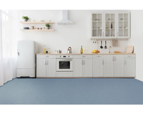 Cuisine claire avec placards intégrés, réfrigérateur et surface de sol bleue