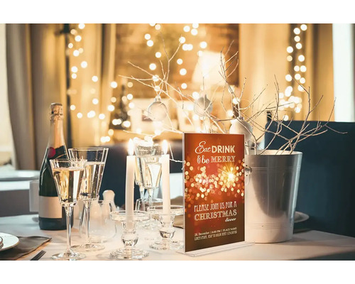 Table festive avec champagne, verres, bougies et carte d''invitation pour un dîner de Noël