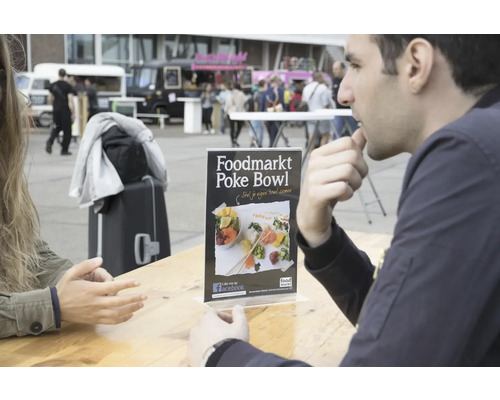 Présentoir avec publicité pour Foodmarkt Poke Bowl sur une table