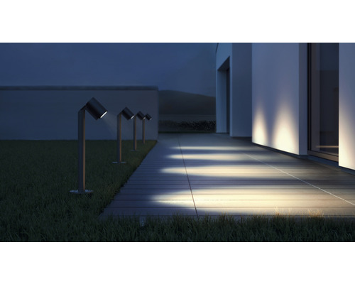 Beleuchtete Auffahrt mit mehreren Wegeleuchten neben einem Haus