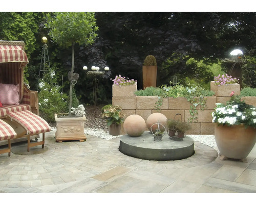 Espace de jardin aménagé avec une chaise de plage, un mur et des jardinières.