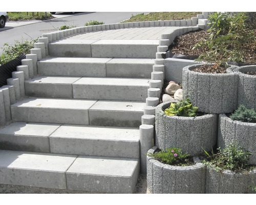 Außentreppe aus Betonsteinen mit runden Begrenzungen und bepflanzten Betonblumentöpfen