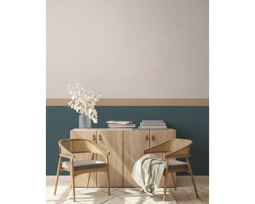 Wohnzimmer mit Kommode, Blumen, Büchern und zwei Stühlen mit Kissen